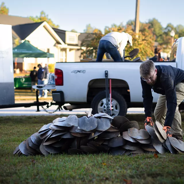 men unloading shovels from truck