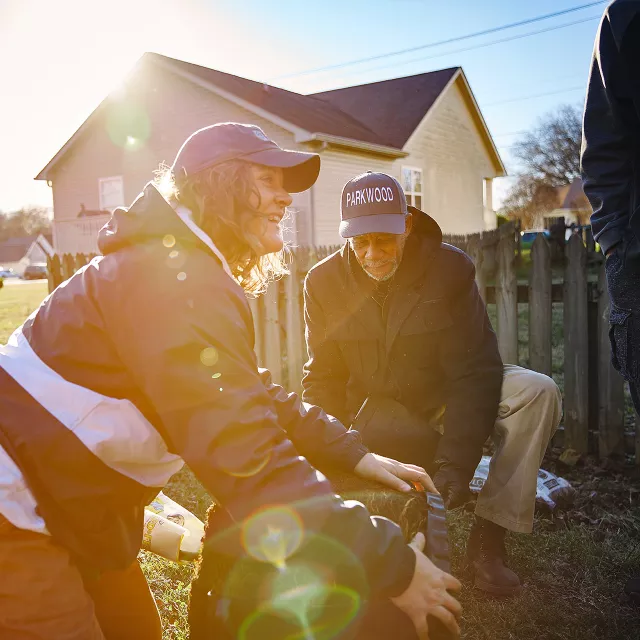 woman and man planting a tree in a backyard