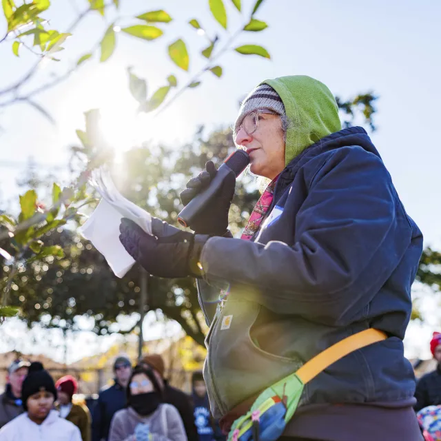 a person instructing volunteers on tree planting