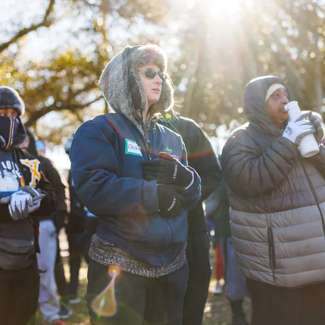 Volunteers standing together, morning sunlight flare overhead.
