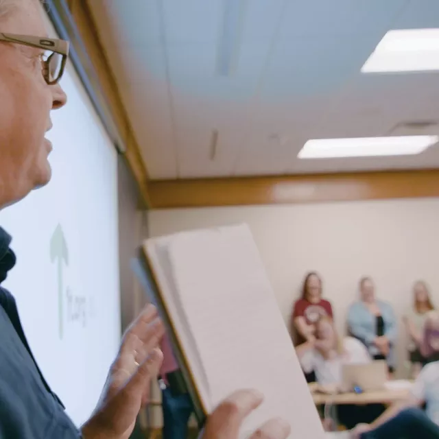 presenter speaking to group.