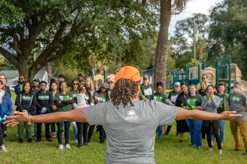community tree planting partner speaking to large group of volunteers.