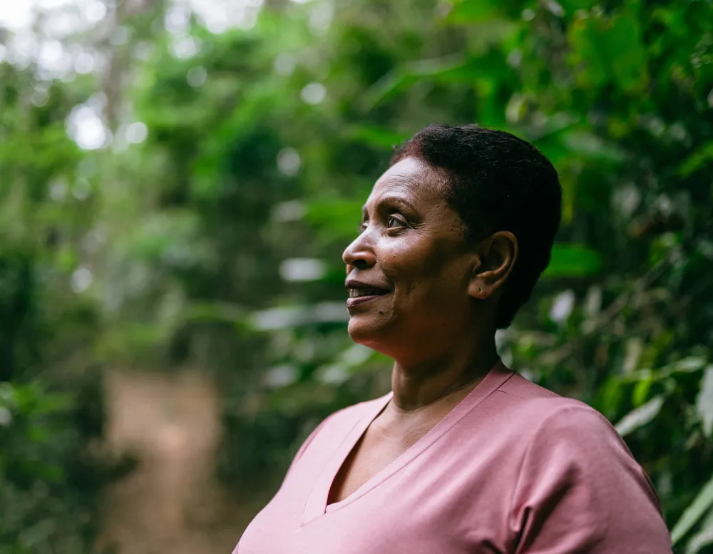 woman smiling and looking out at trees.