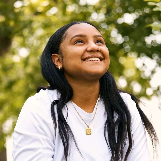girl looking at trees with a hopeful smile