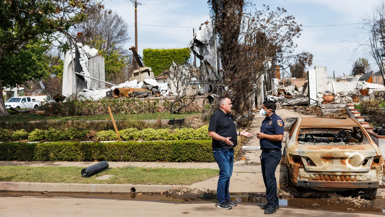 CEO of Arbor Day Foundation walks with a planting partner in Los Angeles through an area devasted by fire.