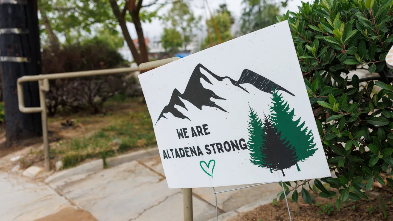 A single sign that reads, "We are Altedena Strong" stands along a sidewalk.