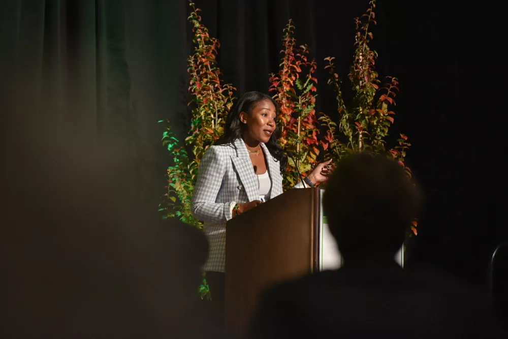Woman speaking at a podium on a stage.