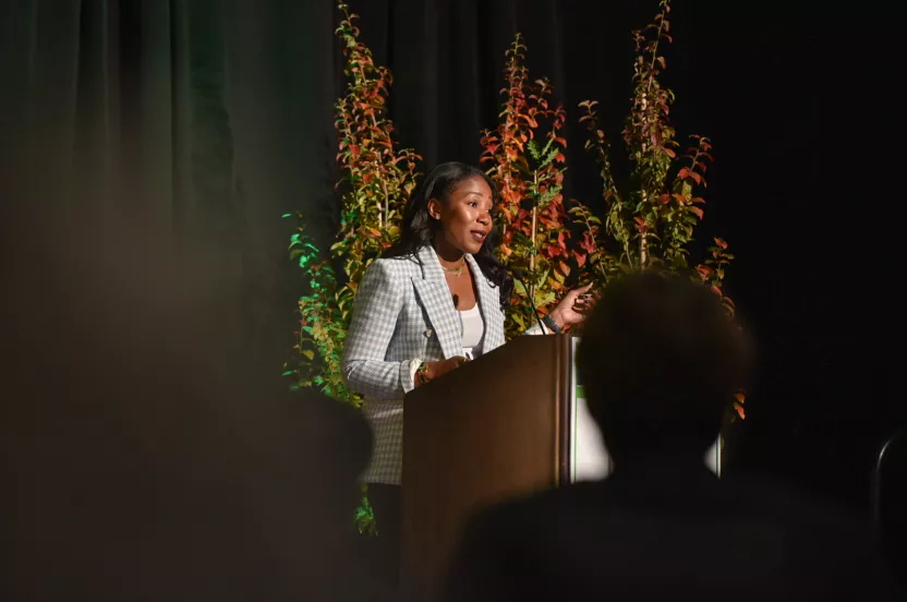 Woman speaking at a podium on a stage.