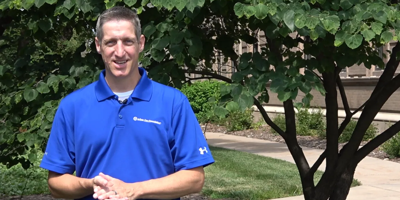 Man standing in front of an eastern redbud tree.